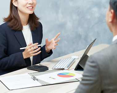 金融機関の担当者と対面し、不動産投資の具体的な資金計画を相談している様子。