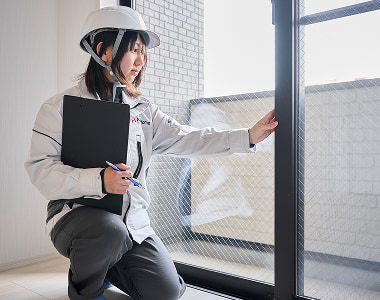  福岡のアパート建築現場において、アパックスホームのスタッフが自社施工の窓枠の品質を入念に点検する様子。