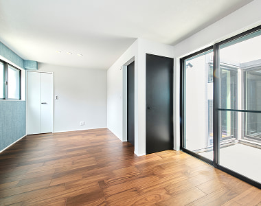 アパックスホームで自社施工した大きな窓と木目調のフローリングが美しい管理物件の室内。