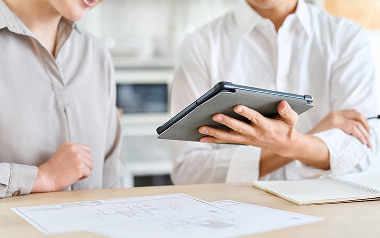 複数の収支シミュレーションを比較しながら、不動産投資を検討する様子。